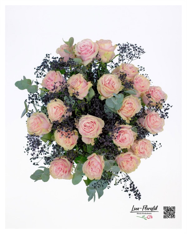 Aus der Vogelperspektive zeigt sich der Strauß als dichtes, harmonisches Arrangement, in dem die zarten rosa Rosen von dunklem Schleierkraut umspielt werden, während die Eukalyptusblätter einen dezenten grünen Rahmen bilden.
