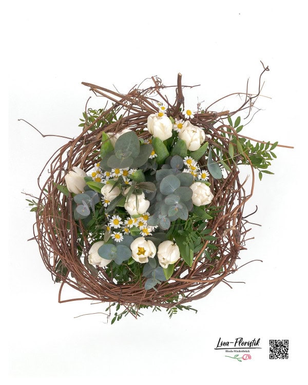 Der Frühlingsstrauß aus der Vogelperspektive: weiße Tulpen, zarte Kamille und Eukalyptus, umrahmt von einem natürlichen Zweigkranz